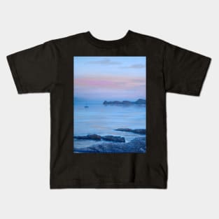 LOOKING TOWARDS PORTITXOL FROM CALA BLANCA BEACH AS THE SUN DISSAPEARS LEAVING A PURPLE BLUE SKY Kids T-Shirt